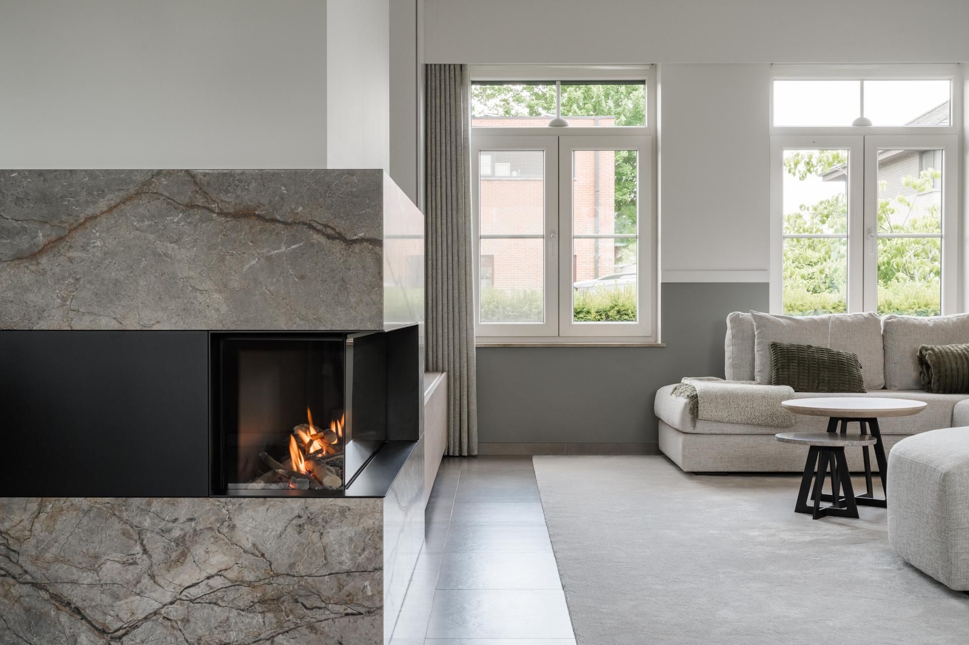 Stijlvol interieur met een modern haardmeubel; natuurlijke materialen en comfort centraal in licht woonkamerdesign.