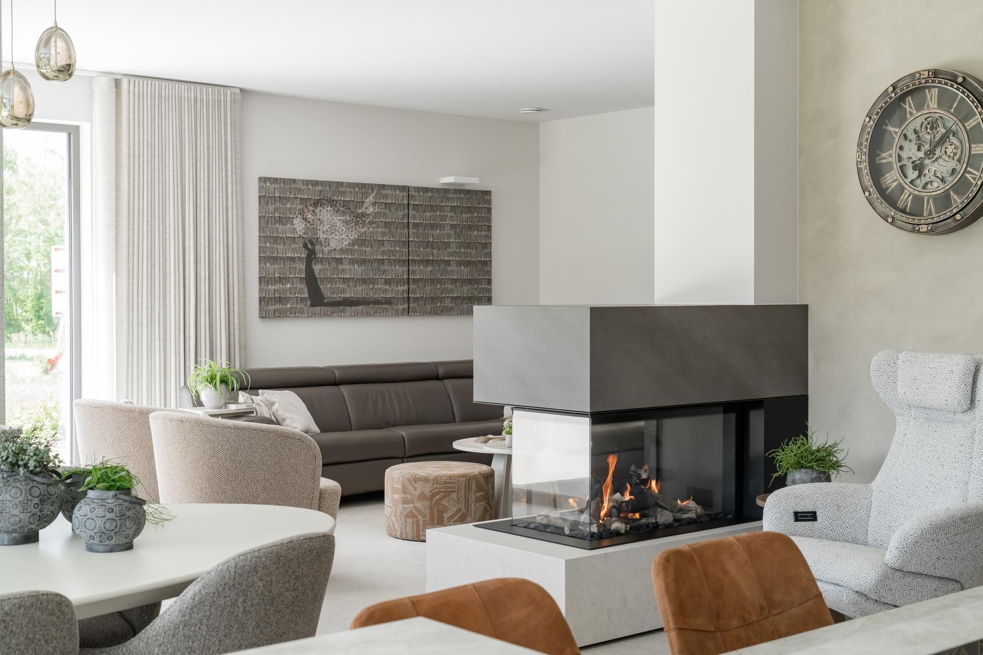Gezellige woonkamer met moderne open haard, comfortabele zitmeubels en esthetisch wanddecor. Perfecte balans tussen comfort en stijl.