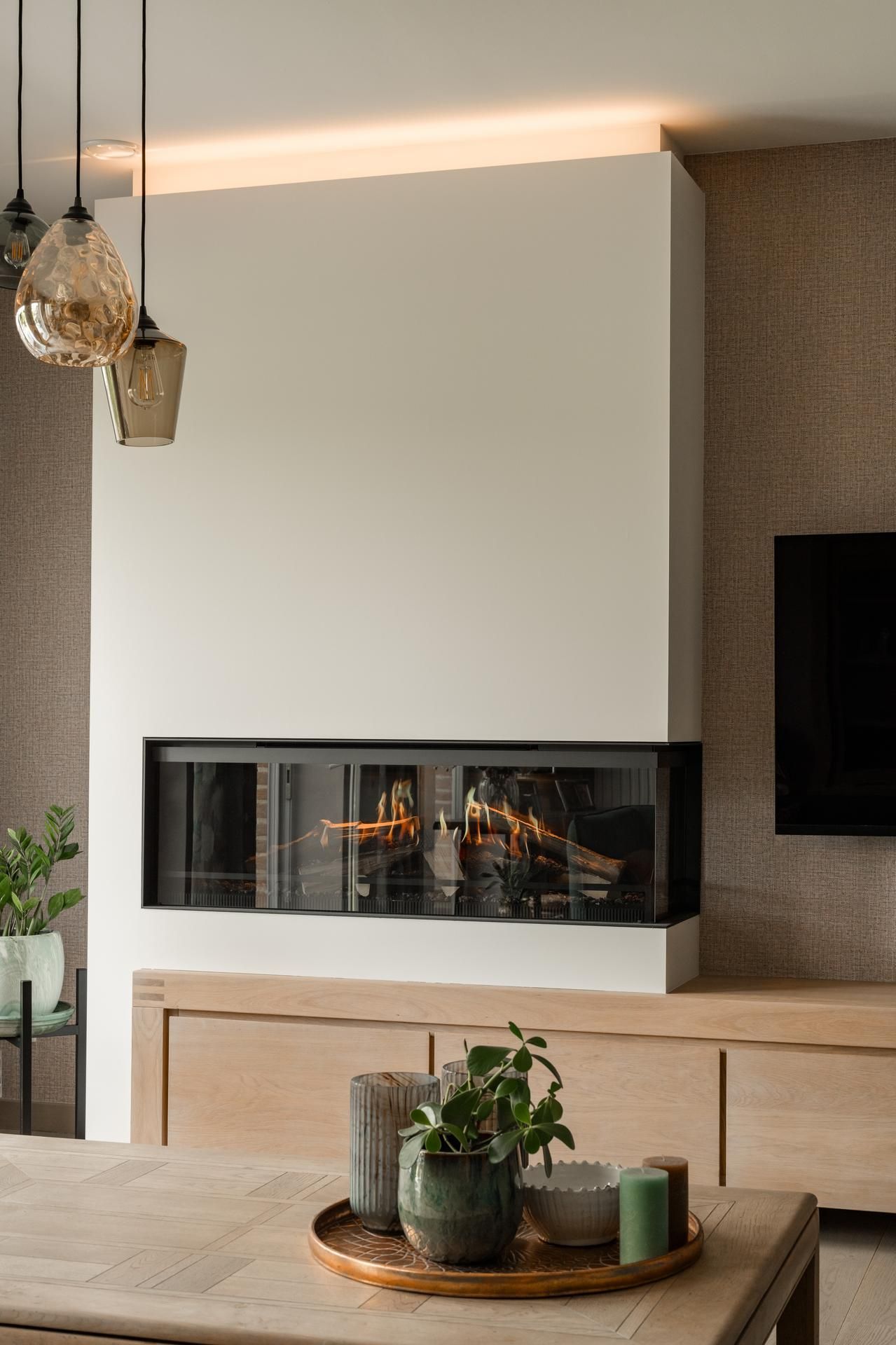 Stijlvol haardmeubel in modern interieur met subtiele verlichting en natuurlijke materialen voor een warme en comfortabele sfeer.