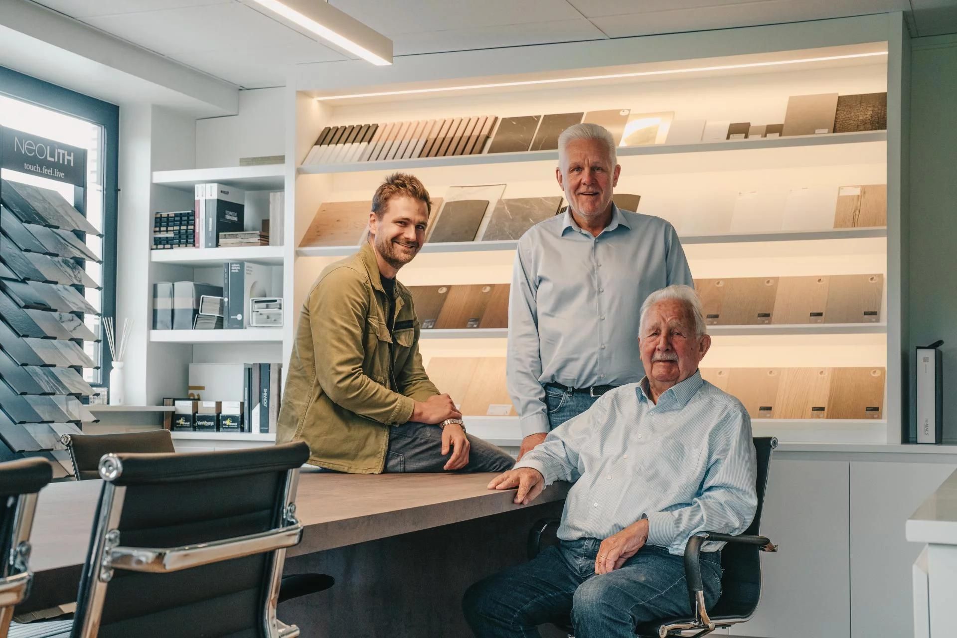 Het team van SA Interieur Atelier, omringd door meubelstalen en ontwerpen.