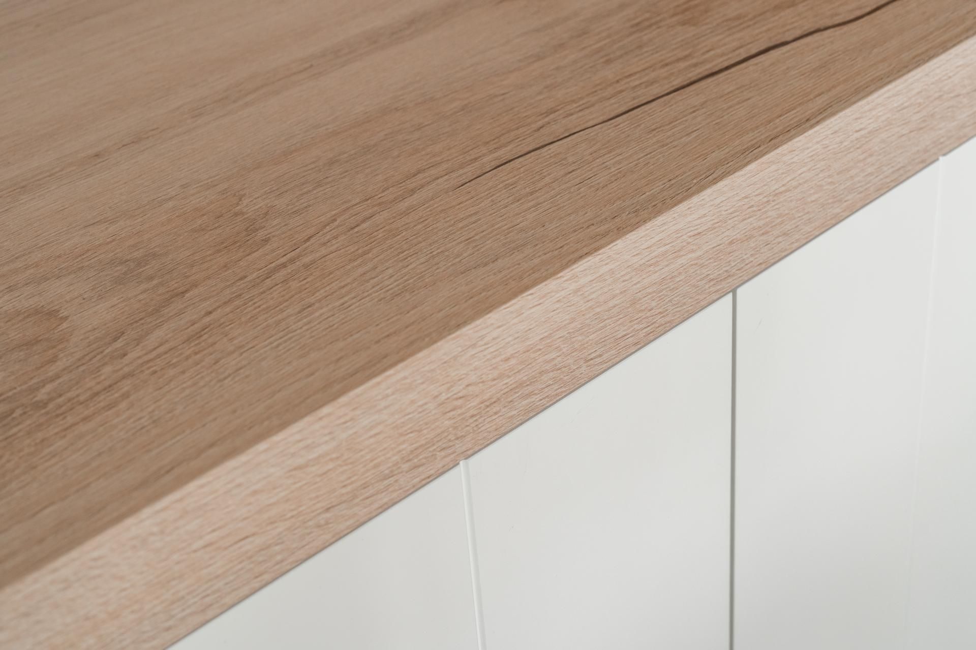 Close-up van een op maat gemaakt houten meubelblad met natuurlijke houtnerf en precisie afwerking voor interieurdesign.